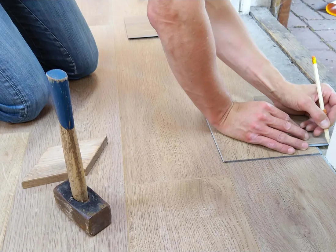 Installer fitting a hybrid floor plank beside a doorway