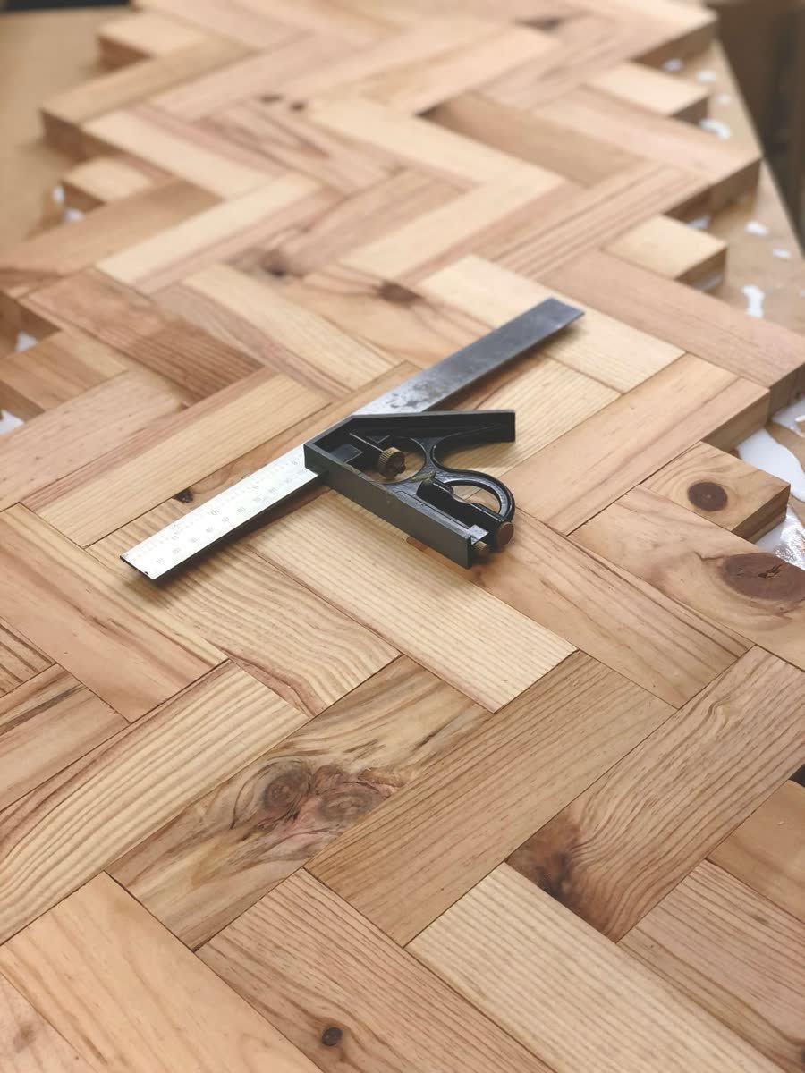 Precision measuring tool on a herringbone timber floor